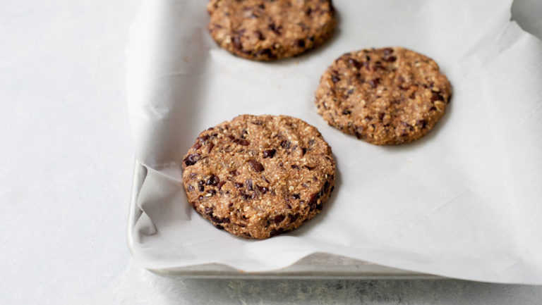 Black bean burger patties on a baking sheet lined with parchment paper