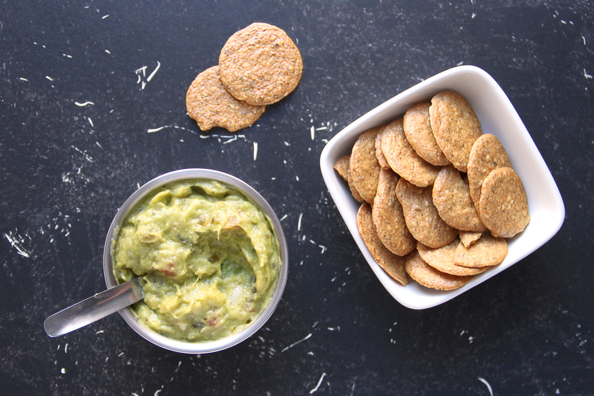 Bowl of cauliflower crackers served with guacamole.