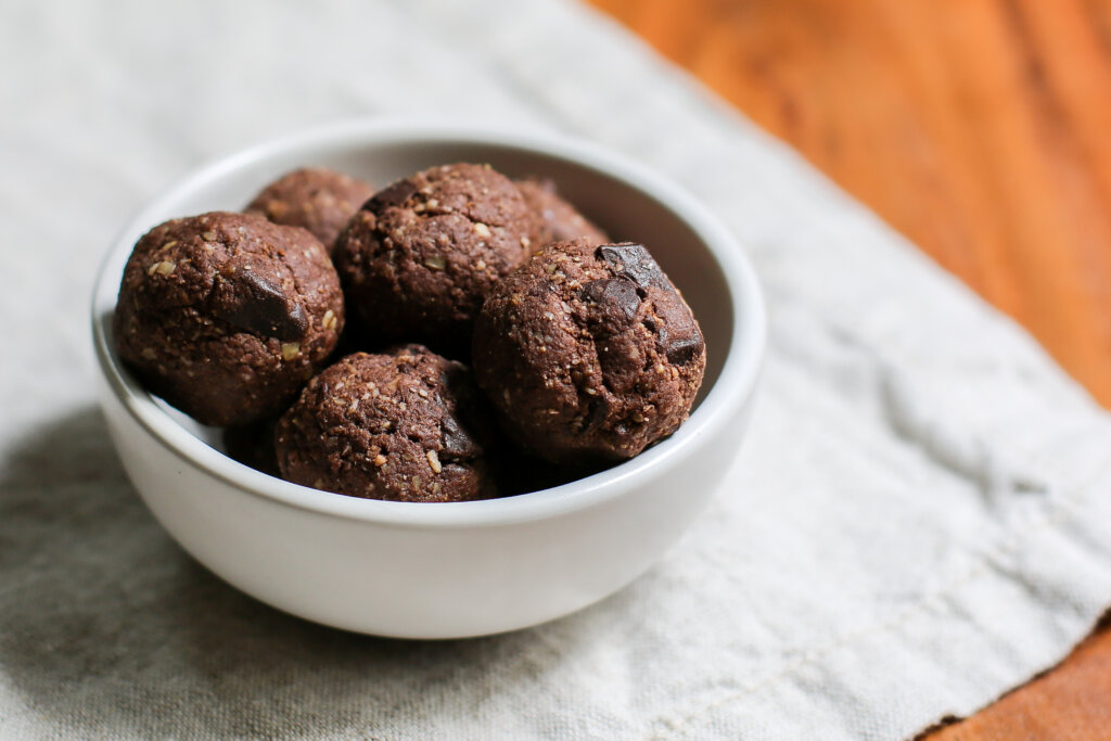 White bowl filled with chocolate protein bites.