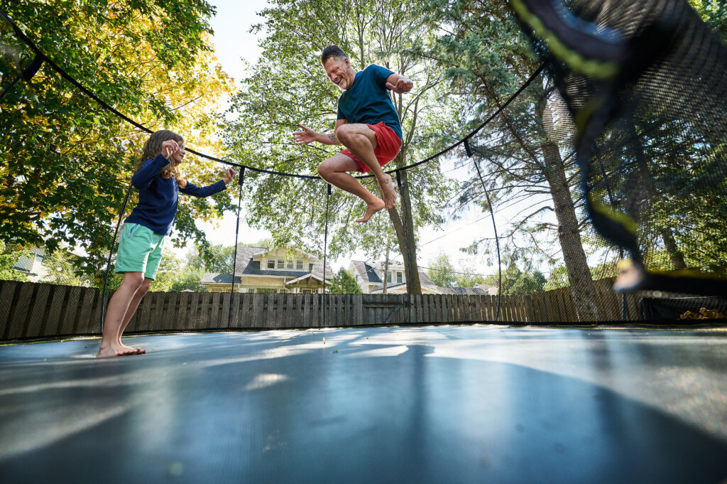 Father and Daughter Jumping on Trampoline
