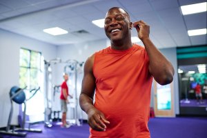 Man smiling and taking out his headphones after doing a strenuous workout.