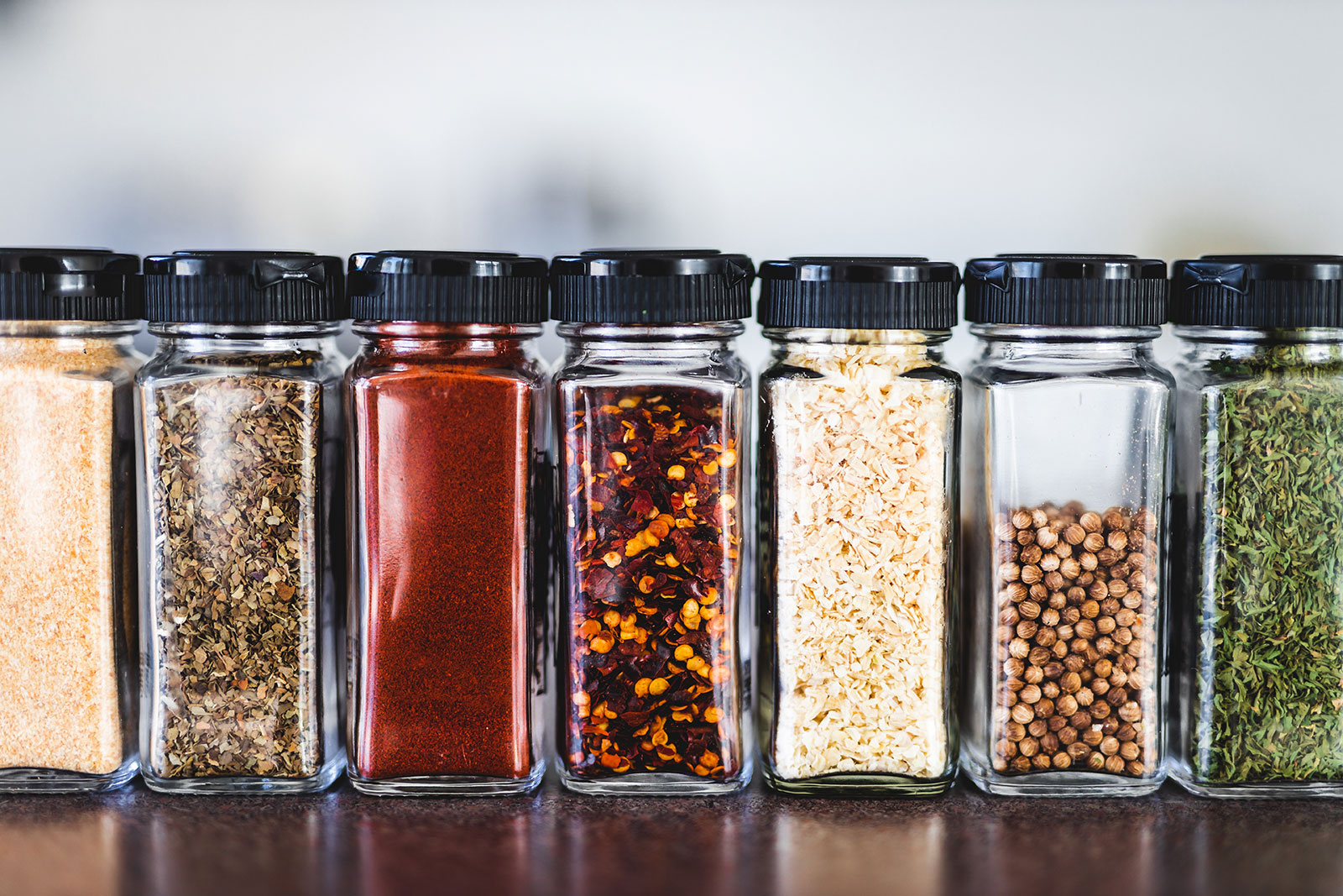 Row of spices in glass containers.
