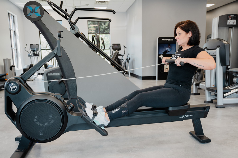 Coach Heather demonstrating the finish on a rowing machine.