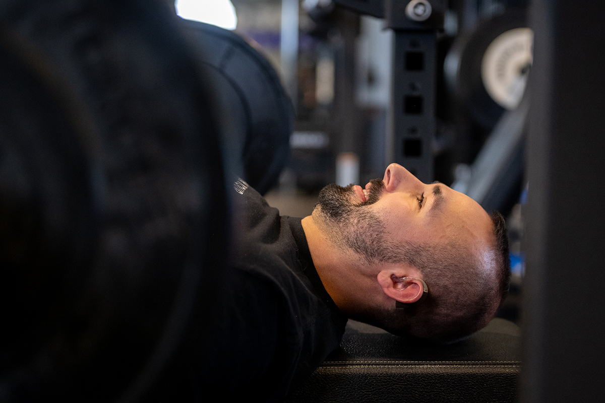 Anytime Fitness Coach Mike laying his head down on a weight bench while doing a bench press.