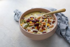 Jalapeño Popper Bean Soup in a pink bowl with a spoon and napkin