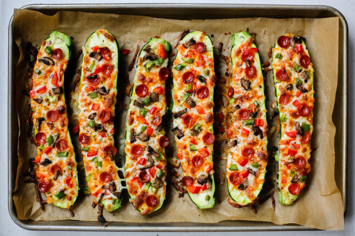 Vegetarian-friendly roasted pizza zucchini boats on a pan.