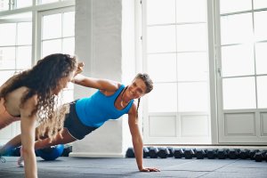 Two women working out in a gym setting.