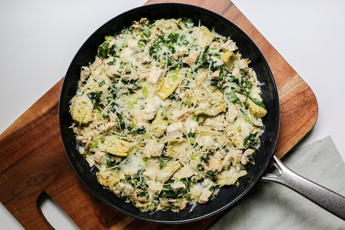Skillet filled with spinach artichoke chicken.
