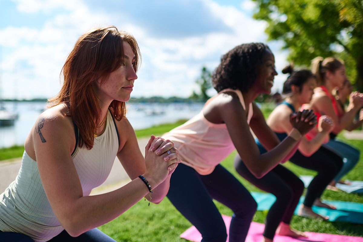 A group of women doing yoga in a park.