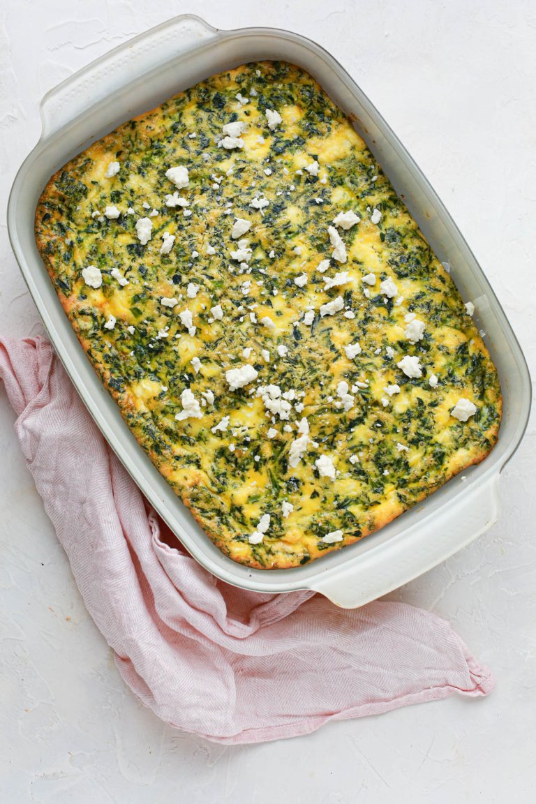 Spinach and feta egg casserole, in a baking dish with a napkin nearby.