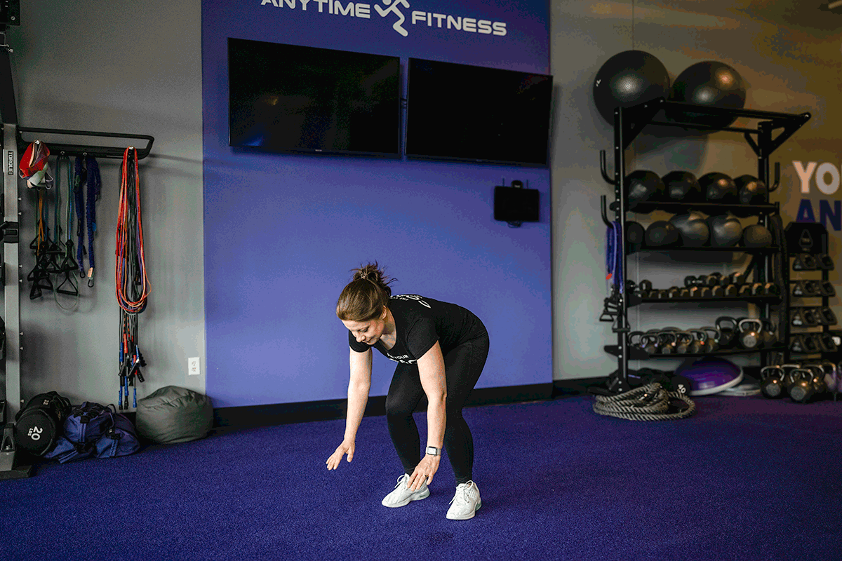 Personal trainer performing a burpee exercise, targeting full-body conditioning and cardio improvement.