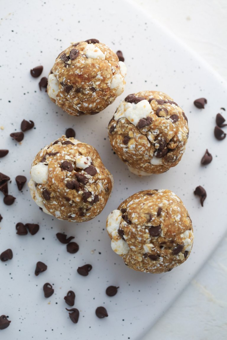 S'mores protein bites made with mini-marshmallows, chocolate chips, quick oats and graham cracker crumbs, arranged on a plate.