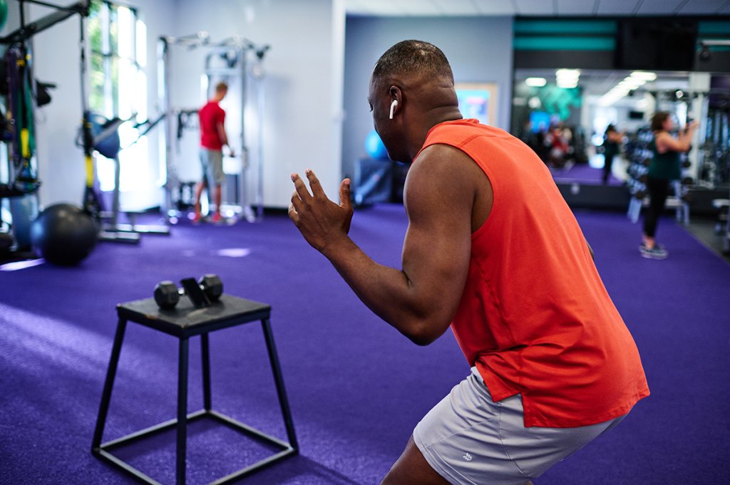 Man working out with headphones in a gym setting.