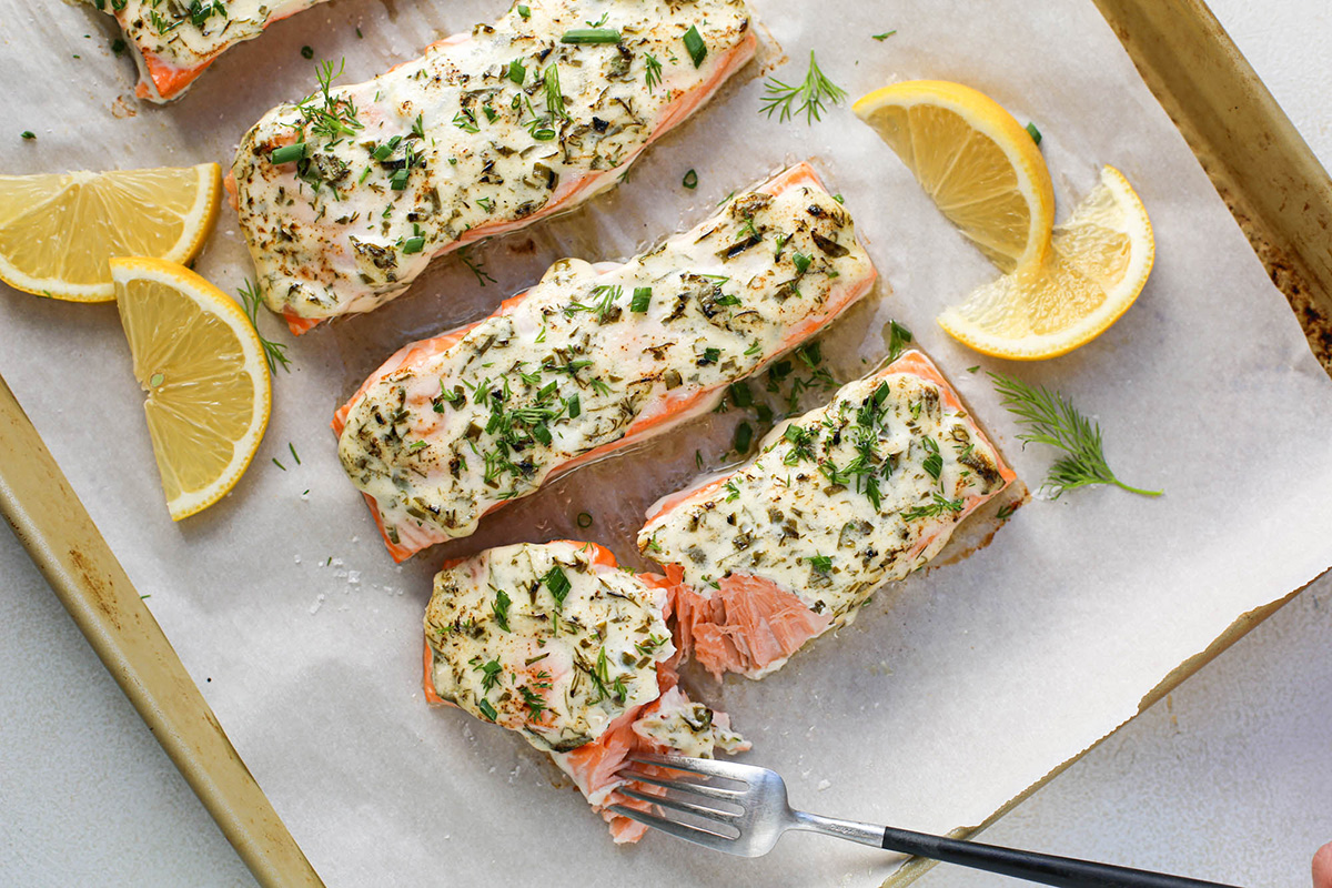 Baked herb-crusted salmon with lemon slices, a nutritious and flavorful main dish for holidays.