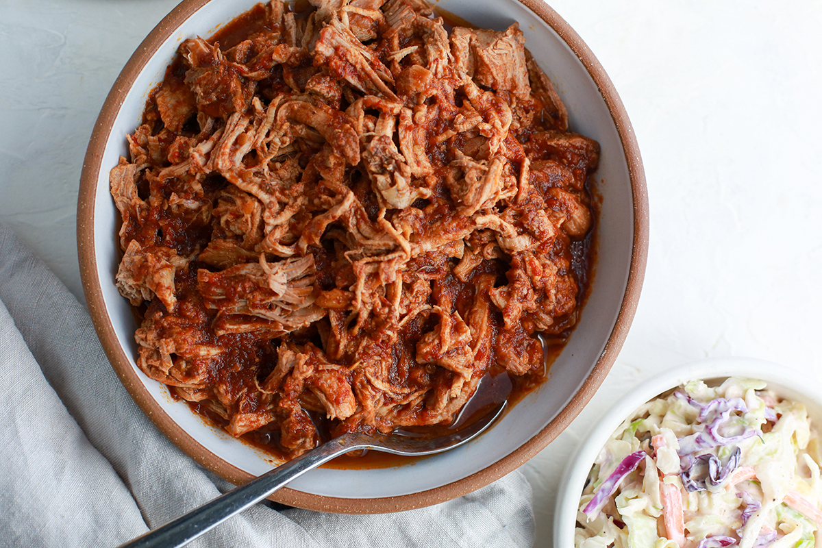 Savory pulled pork in a rich sauce served alongside coleslaw, a flavorful and protein-rich holiday main course.