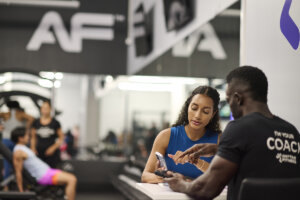 An Anytime Fitness Coach helps a gym member create a customized workout plan in the Anytime Fitness App.